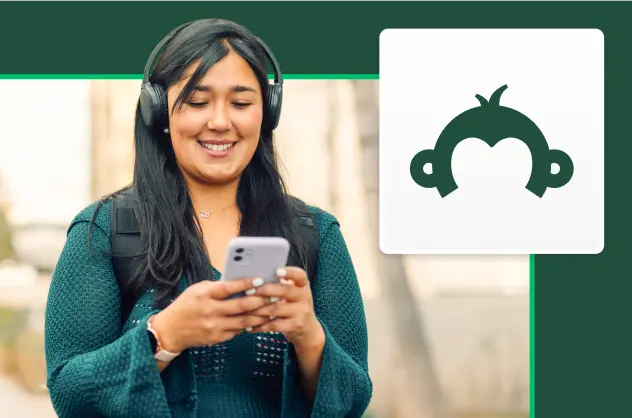 Leende kvinna med hörlurar som tittar på en mobilskärm, bredvid SurveyMonkeys Goldie-logotyp